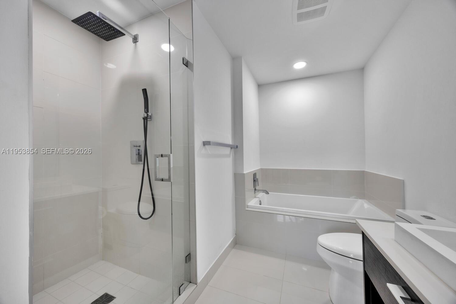 55 Southwest 9th Street, Unit 2406 Miami, FL 33130 - Photo 11 of 38 a bathroom with a granite countertop sink toilet and shower