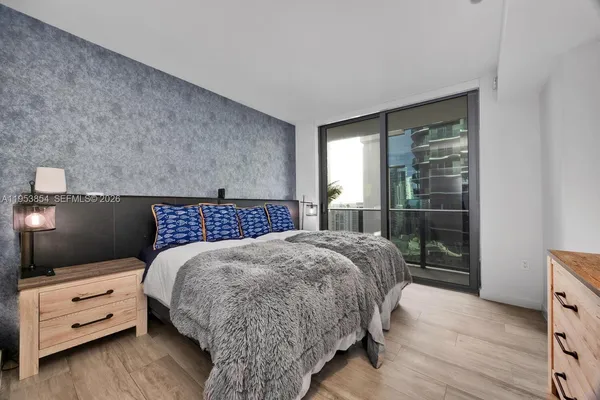 a bedroom with a bed and large window