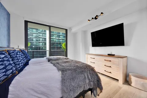 a bedroom with a bed and a flat screen tv