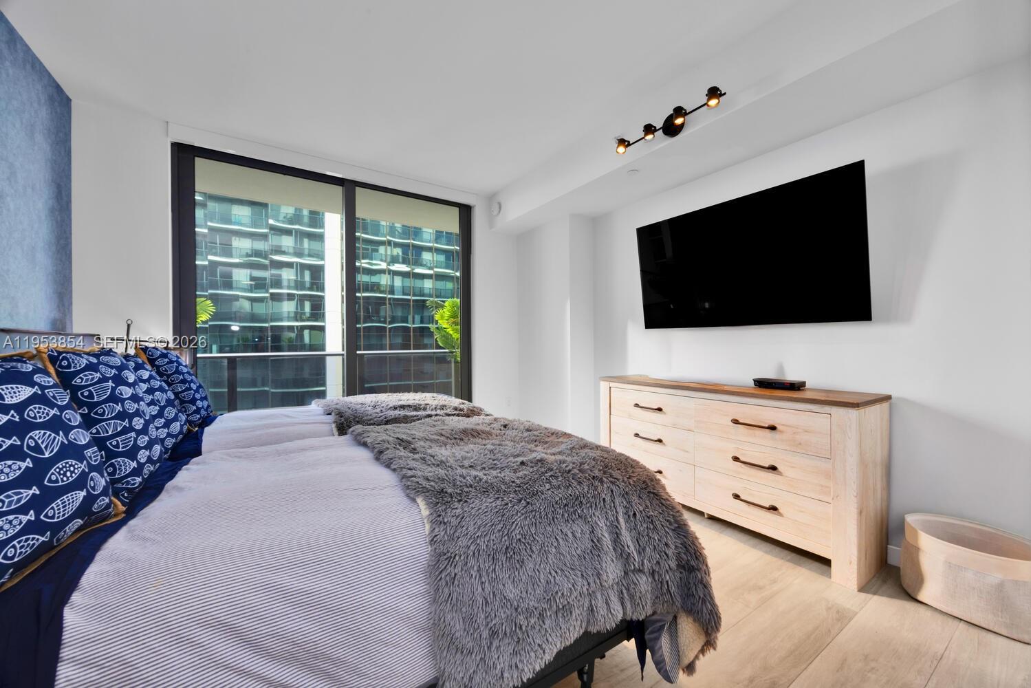 55 Southwest 9th Street, Unit 2406 Miami, FL 33130 - Photo 13 of 38 a bedroom with a bed and a flat screen tv