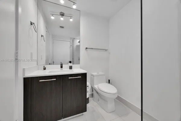 a bathroom with a sink toilet and mirror