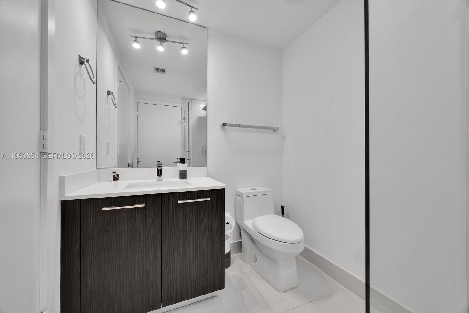 55 Southwest 9th Street, Unit 2406 Miami, FL 33130 - Photo 14 of 38 a bathroom with a sink toilet and mirror