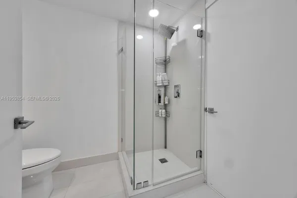 a bathroom with a shower a toilet and a sink