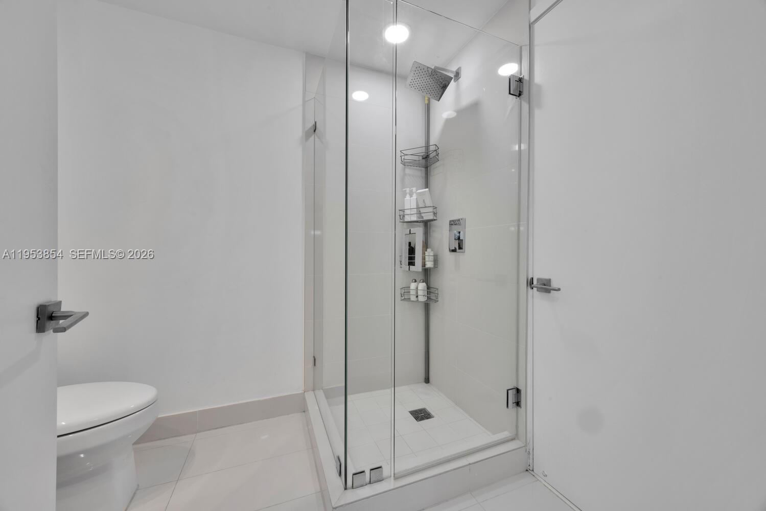 55 Southwest 9th Street, Unit 2406 Miami, FL 33130 - Photo 15 of 38 a bathroom with a shower a toilet and a sink