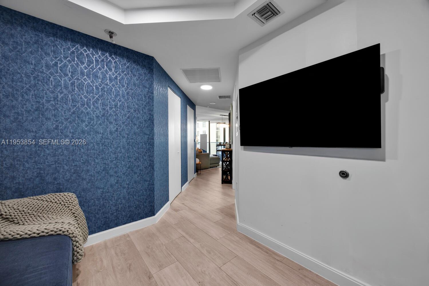 55 Southwest 9th Street, Unit 2406 Miami, FL 33130 - Photo 16 of 38 a hallway with a flat screen tv and a refrigerator