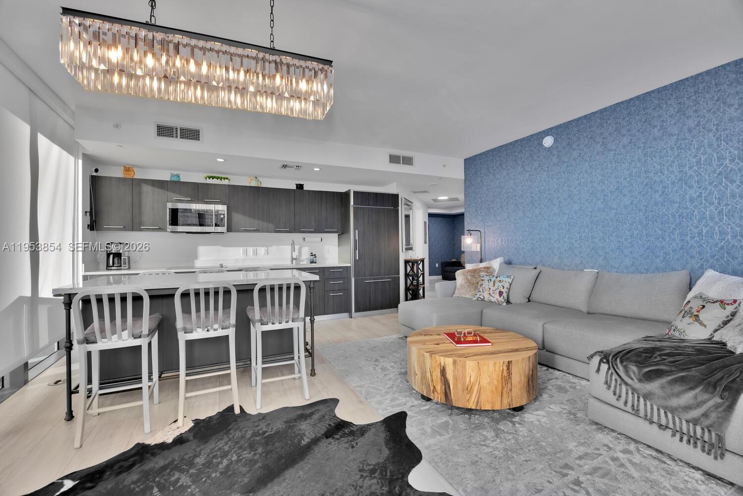 55 Southwest 9th Street, Unit 2406 Miami, FL 33130 - Photo 18 of 38 a living room with furniture and a chandelier