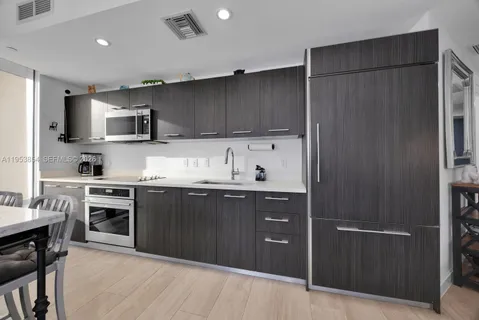 a kitchen with stainless steel appliances granite countertop a refrigerator and a stove top oven