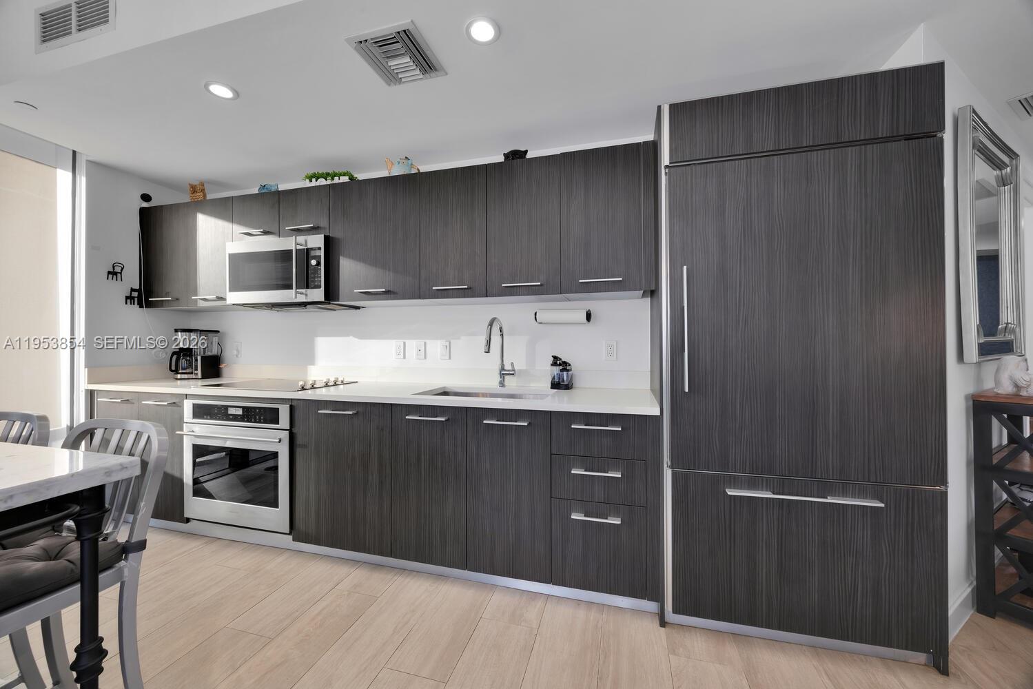 55 Southwest 9th Street, Unit 2406 Miami, FL 33130 - Photo 4 of 38 a kitchen with stainless steel appliances granite countertop a refrigerator and a stove top oven