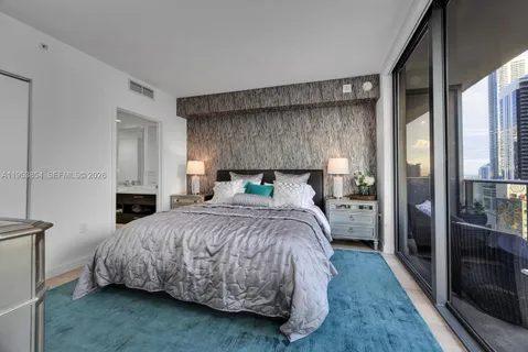 a bedroom with a bed a mirror and a dresser