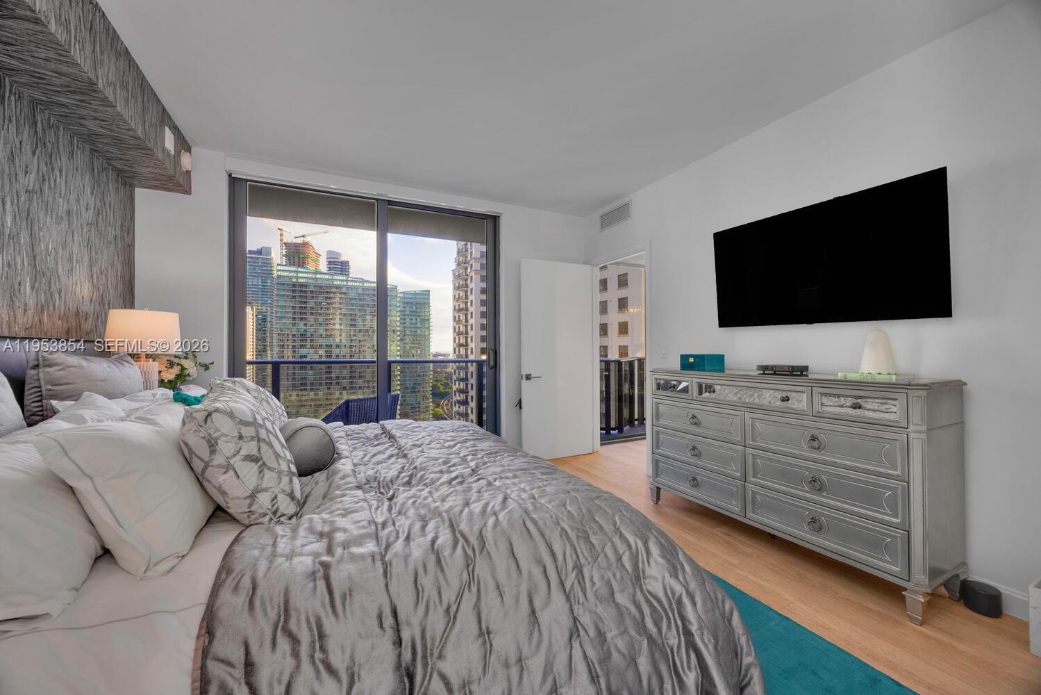 55 Southwest 9th Street, Unit 2406 Miami, FL 33130 - Photo 9 of 38 a bedroom with a bed and a flat screen tv