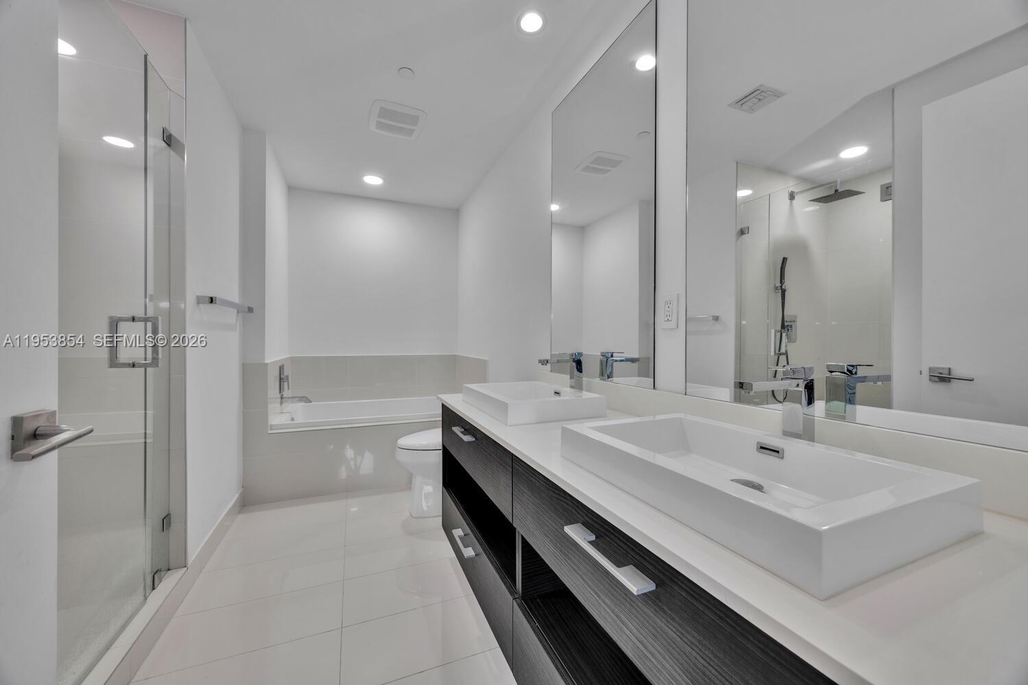 55 Southwest 9th Street, Unit 2406 Miami, FL 33130 - Photo 10 of 38 a bathroom with a double vanity sink a toilet and a shower