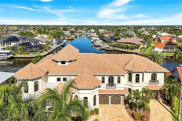 an aerial view of residential houses with outdoor space and ocean view