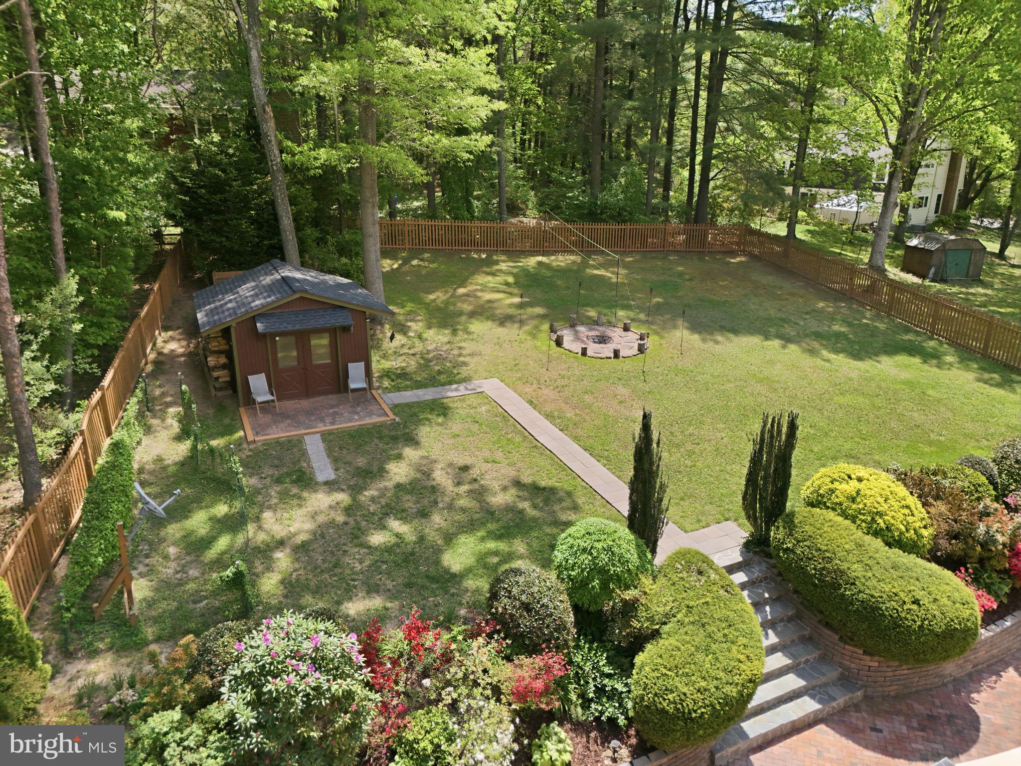 10929 Howland Drive Reston, VA 20191 - Photo 45 of 66 a view of a garden with lawn chairs under an umbrella