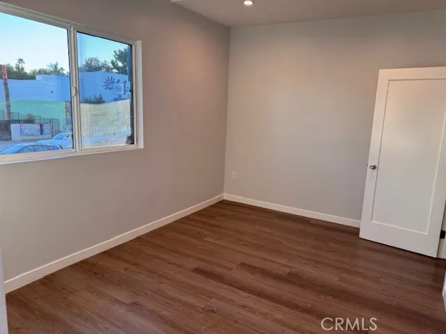 an empty room with wooden floor and closet