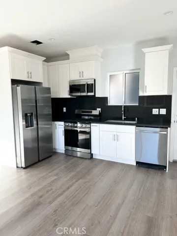 a kitchen with granite countertop a refrigerator and a stove top oven