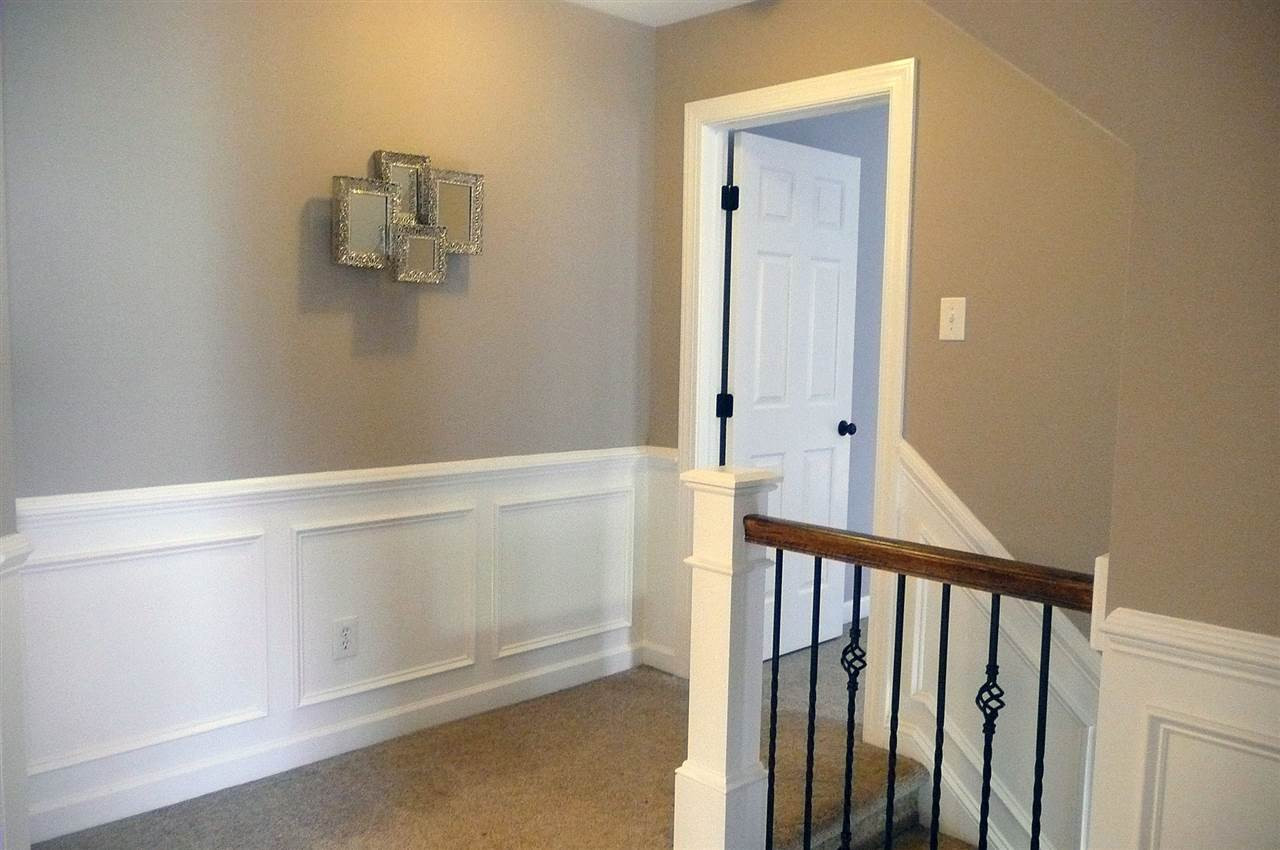 4905 Gable Ridge Lane Holly Springs, NC 27540 - Photo 9 of 25 The staircase has been updated with wrought iron spindles adding an elegant look to this home. Both the staircase and the upstairs hallway have wainscoting. Upstairs Hallway
