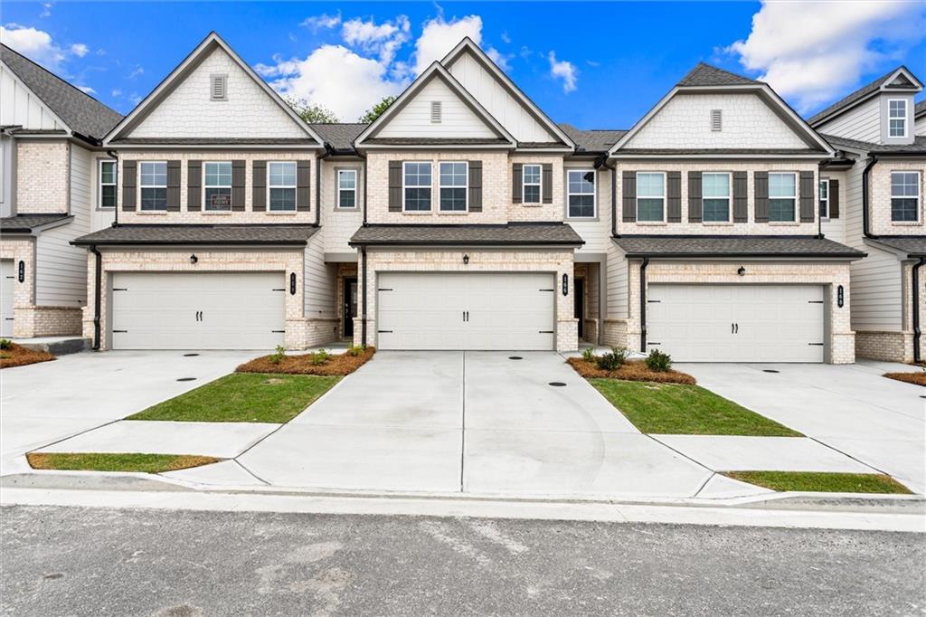 a view of house with a yard and garage