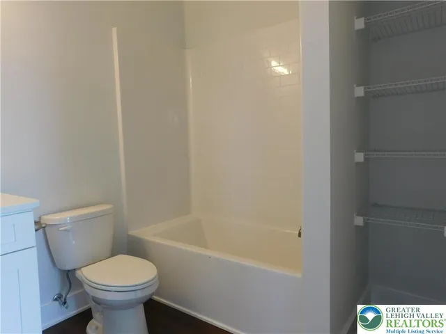 a white toilet sitting next to a white tub