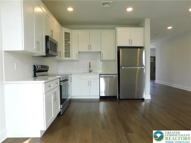 a kitchen with stainless steel appliances a refrigerator stove microwave and cabinets