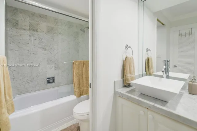 a bathroom with a sink a toilet a mirror and shower