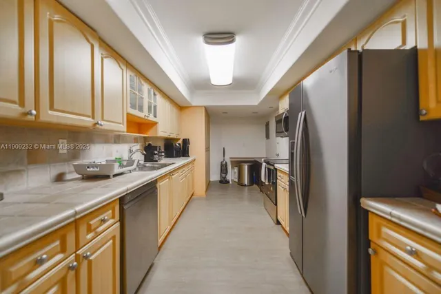 a kitchen with stainless steel appliances granite countertop a refrigerator a stove and a sink