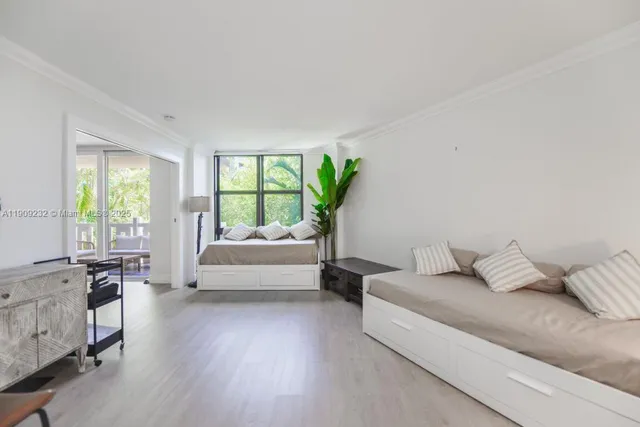 a bedroom with furniture and a large window