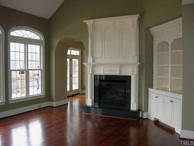 9020 Chelsea Drive Raleigh, NC 27603 - Photo 3 of 10 an empty room with wooden floor windows and a fireplace