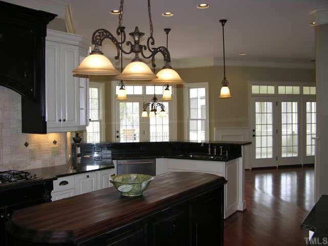 9020 Chelsea Drive Raleigh, NC 27603 - Photo 4 of 10 a kitchen with stainless steel appliances granite countertop a sink a stove and a wooden floor