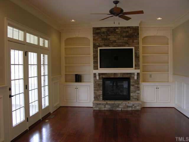 9020 Chelsea Drive Raleigh, NC 27603 - Photo 6 of 10 a living room with a fireplace and a floor to ceiling window