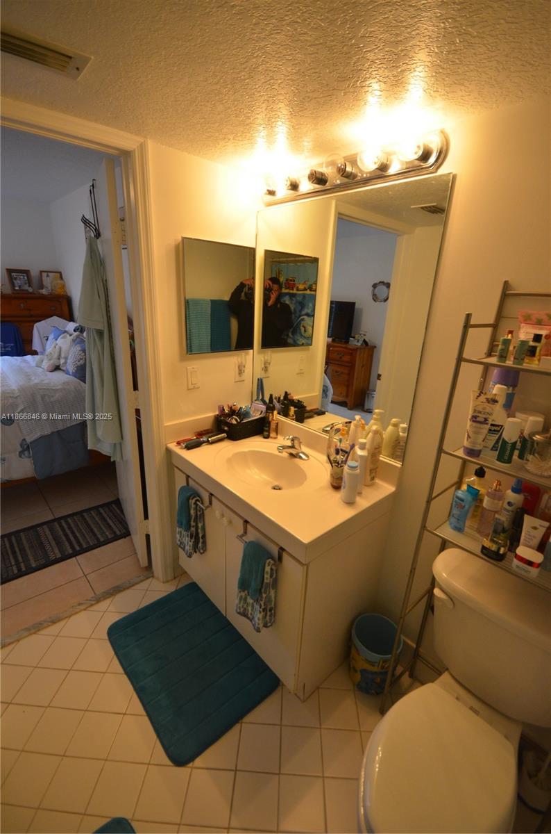 1270 Southeast 27th Street, Unit 101 Homestead, FL 33035 - Photo 22 of 32 a bathroom with a sink mirror vanity and toilet