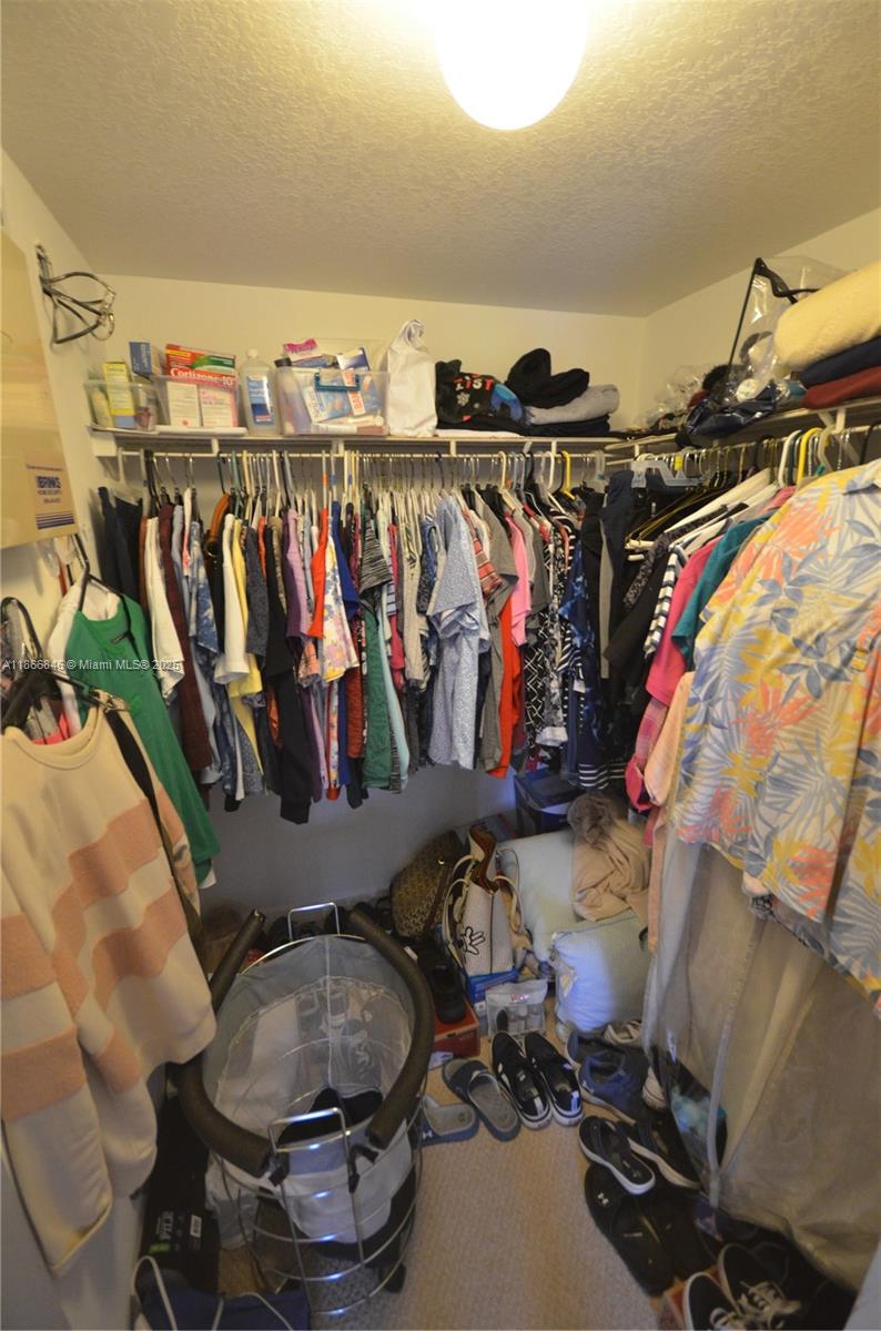 1270 Southeast 27th Street, Unit 101 Homestead, FL 33035 - Photo 23 of 32 a view of walk in closet with clothes and shoes