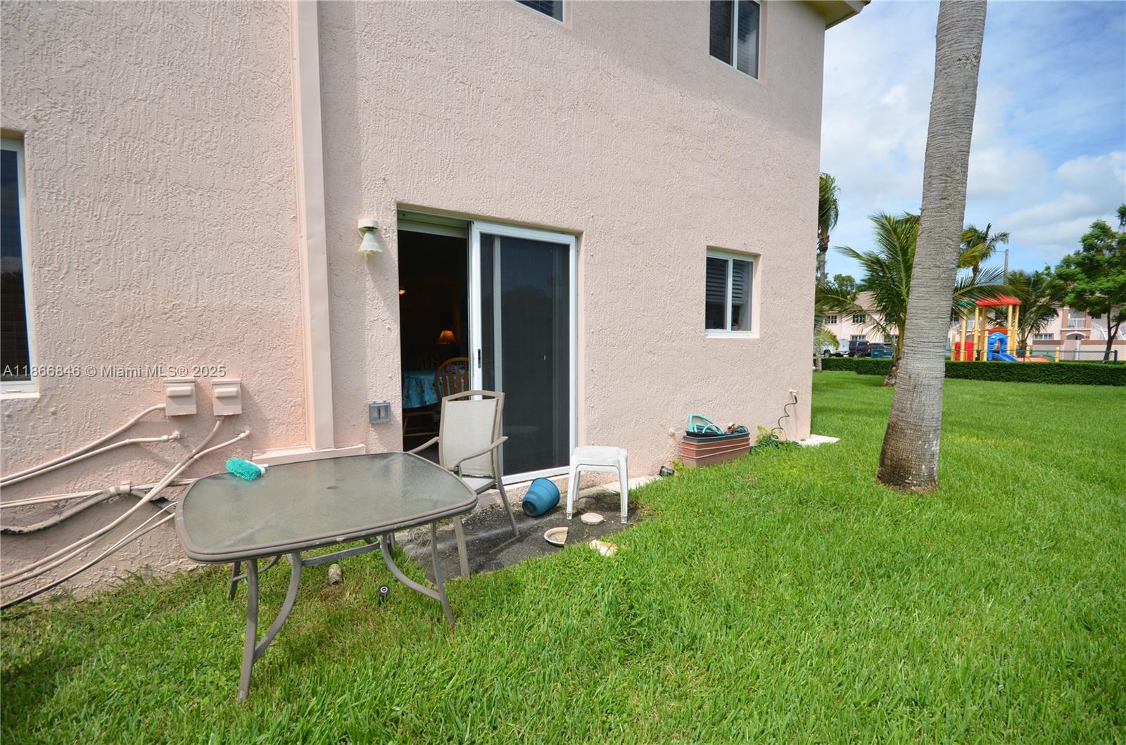 1270 Southeast 27th Street, Unit 101 Homestead, FL 33035 - Photo 32 of 32 a backyard of a house with table and chairs