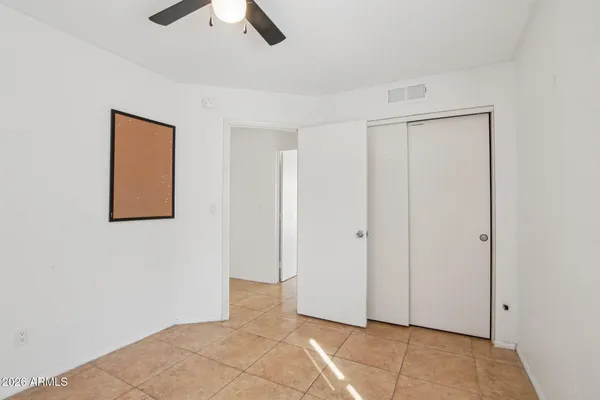an empty room with windows and fan