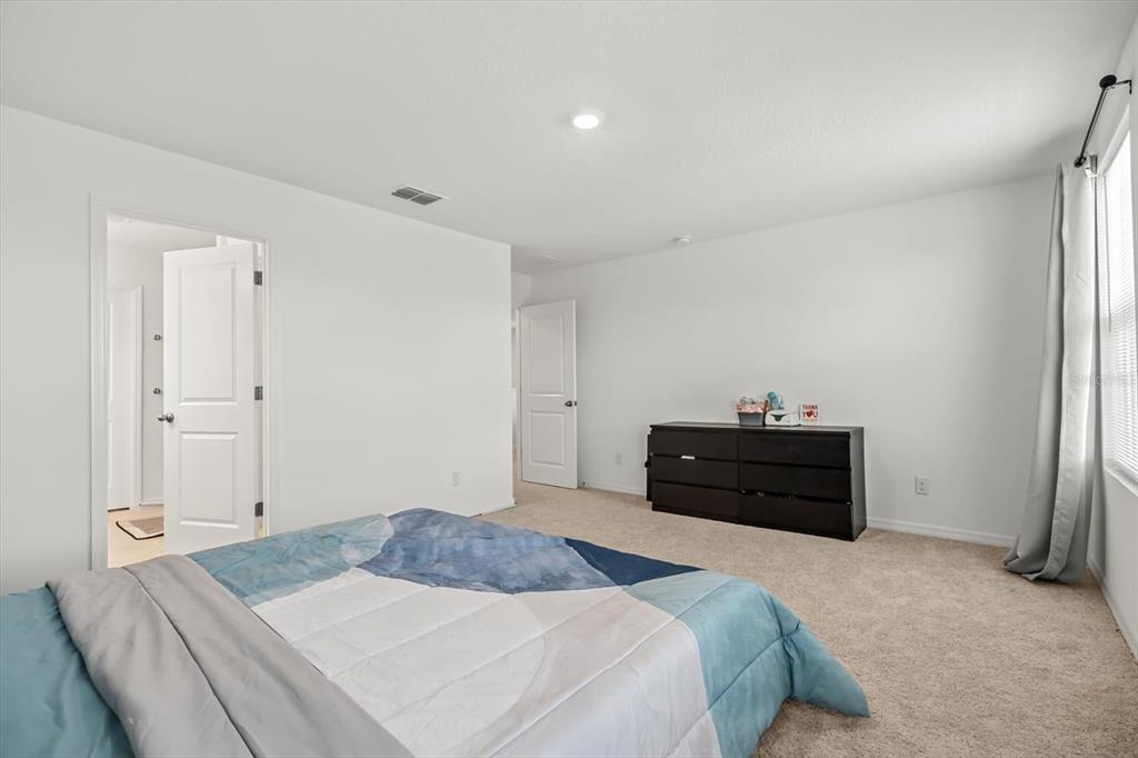 17061 Seville Orange Road Winter Garden, FL 34787 - Photo 24 of 42 a bedroom with a bed and a dresser