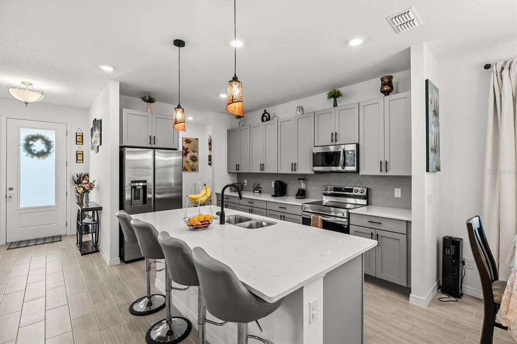 17061 Seville Orange Road Winter Garden, FL 34787 - Photo 6 of 42 a kitchen with a table chairs refrigerator and microwave