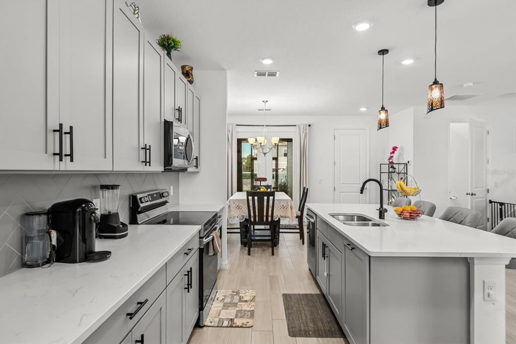 17061 Seville Orange Road Winter Garden, FL 34787 - Photo 7 of 42 a kitchen that has a lot of cabinets in it and wooden floors