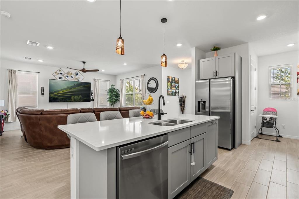 17061 Seville Orange Road Winter Garden, FL 34787 - Photo 8 of 42 a kitchen with a sink a counter top space stainless steel appliances and a center island