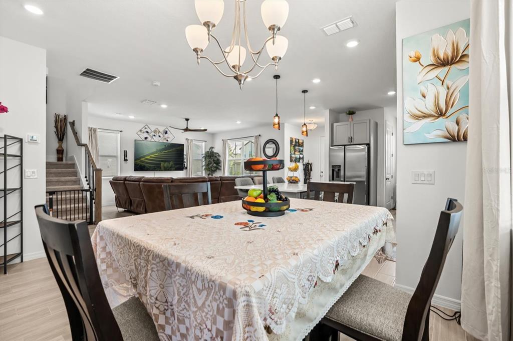 17061 Seville Orange Road Winter Garden, FL 34787 - Photo 10 of 42 a kitchen with stainless steel appliances kitchen island granite countertop a table chairs and a refrigerator