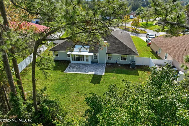 an aerial view of a house with a yard table and chairs