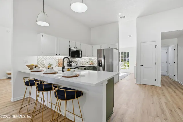 a view of kitchen with sink refrigerator dining table and chairs