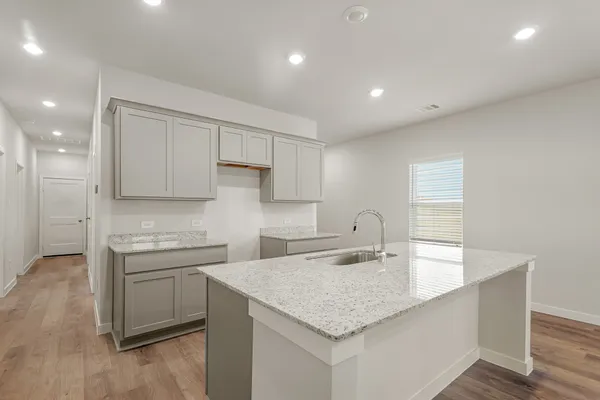 a kitchen that has a sink a stove and cabinets