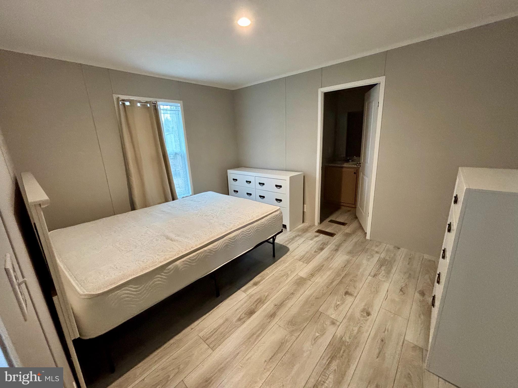12623 Shell Mill Road, Unit 124 Bishopville, MD 21813 - Photo 5 of 10 a bedroom with a bed and wooden floor