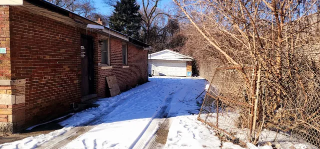 a view of backyard with wooden fence and large trees