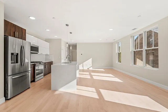 a kitchen with stainless steel appliances kitchen island a refrigerator sink and stove