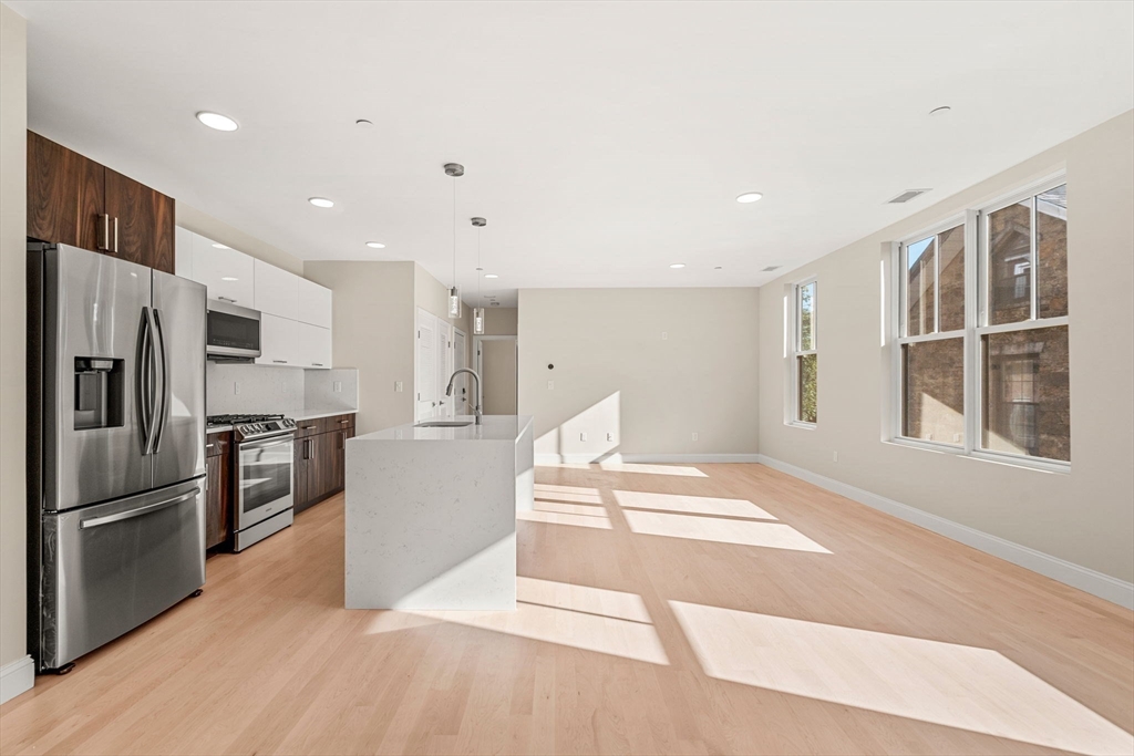 124 Warren Street, Unit 202 Boston, MA 02119 - Photo 12 of 23 a kitchen with stainless steel appliances kitchen island a refrigerator sink and stove