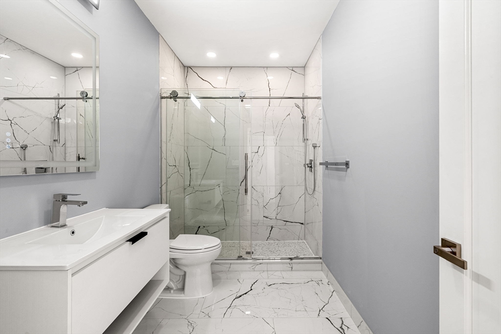 124 Warren Street, Unit 202 Boston, MA 02119 - Photo 15 of 23 a bathroom with a sink a toilet and shower