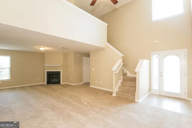 an empty room with windows and pillars ceiling fan