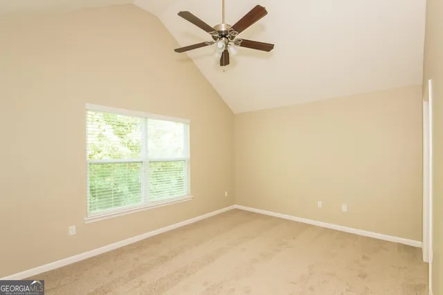an empty room with a window and a fan