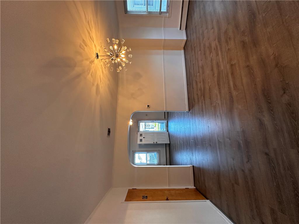 5128 3rd Street Whitehall, PA 18052 - Photo 14 of 26 A stylish ceiling light fixture illuminates the inviting wood flooring, enhancing the room's elegant appeal.