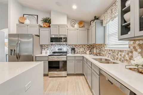 a kitchen with stainless steel appliances a sink stove and refrigerator
